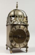 AN 18TH CENTURY BRASS LANTERN CLOCK of typical form, with bell, silvered chapter ring and engraved