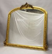 A LARGE GILTWOOD OVERMANTLE MIRROR with domed top, shell and flowers. 5ft 2ins high x 5ft wide.