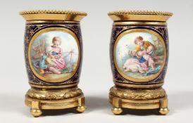 A GOOD SMALL PAIR OF SEVRES PORCELAIN ORMOLU MOUNTED POTS, rich blue ground with reverse panels of