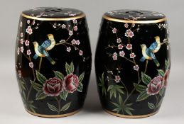 A PAIR OF BLACK CHINESE PORCELAIN BARREL SEATS with flowers and birds. 17.5ins high.