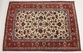 A GOOD PERSIAN ISFAHAN RUG, central cream ground panel with a red ground floral border. 7ft 3ins x