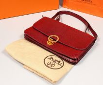 A HERMES BURGUNDY HANDBAG with dust bag and original box.