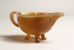 A SUPERB CARVED AGATE JUG, CARVED FROM THE SOLID, with open handles and three legs, possibly Faberge