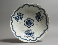 A WORCESTER BLUE AND WHITE JUNKET DISH with moulded decoration and flowers in blue. 9ins diameter,
