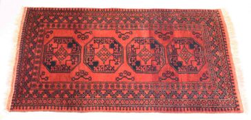 A PERSIAN TEKKE DESIGN RUG, red ground with four large central medallions. 6ft 2ins x 3ft 5ins.
