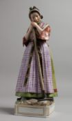 A LARGE COPENHAGEN PORCELAIN FIGURE OF A WOMAN resting on a rake. Inscribed SAMSON. 12ins high.
