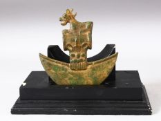 AN ARCHAIC STYLE BRONZE ZOOMORPHIC AXE HEAD on a wooden stand, the axe head, 15cm x 15.5cm.