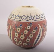 A TURKISH IZNIK POTTERY MOSQUE BALL, decorated with stylised flora, 14cm high.