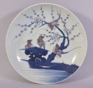 A CHINESE BLUE, WHITE AND IRON RED PORCELAIN DISH, the centre painted with stylised birds on a