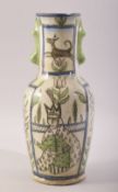 A PERSIAN QAJAR GLAZED POTTERY VASE, painted with figures, flowers and animals, 27.5cm high.