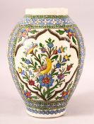 A PERSIAN QAJAR GLAZED POTTERY VASE, painted with three panels depicting a yellow bird amongst