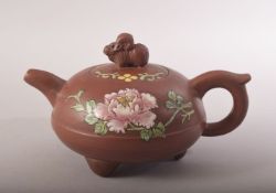 A CHINESE FAMILLE ROSE YIXING CLAY TEAPOT - with poly chrome floral decoration - the cover with a