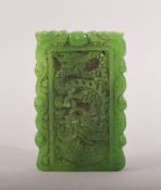 A CHINESE CARVED JADEITE PENDANT, carved with dragon to one side, phoenix to reverse, 9cm x 5.5cm.