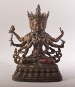 A TIBETAN GILT BRONZE FIGURE OF A MULTI ARM DEITY / BUDDHA - in a seated position holding many