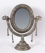 A GOOD INDIAN EMBOSSED WHITE METAL MIRROR ON STAND - the mirror with twin elephant heads