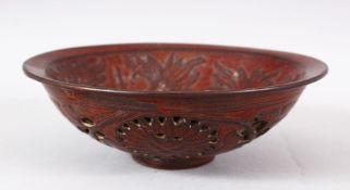 A CHINESE PIERCED POTTERY BOWL - the interior decorated with scenes of flora, the underside with