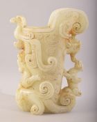 A LARGE CHINESE CARVED PALE GREEN HARDSTONE CUP, the body carved with mythological beasts, 23cm