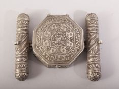 AN ISLAMIC PRAYER / SCROLL BOX - POSSIBLY SILVER, with embossed and chased decoration, 10cm x 8cm.
