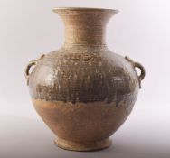 A CHINESE EARTHENWARE TWIN HANDLE POTTERY VASE, the shoulders with treacle glaze, 33cm high.
