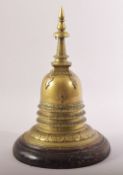 A RARE INDIAN BRASS STUPA, fitted to a wooden stand, 28cm high.