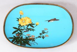 A JAPANESE BLUE GROUND OVAL CLOISONNE DISH, decorated with native flowers and a bird, 24.5cm x 17.