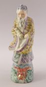 A CHINESE FAMILLE ROSE PORCELAIN FIGURE OF A SAGE, stood upon a wave formation with a mask of a