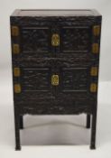 A GOOD CHINESE HARDWOOD / HONGMU FOUR DOOR CABINET on stand, the front profusely carved with a