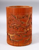 A CHINESE BAMBOO BRUSH POT, carved with a landscape scene and figures, 17cm high.