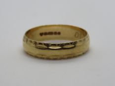 A 9ct gold ring having border pattern, hallmarked 375, size O-P, 2.2g.