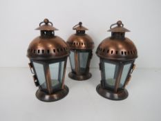 A set of three copper coloured lanterns, each standing 22cm high inc hanging loop.