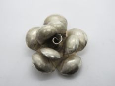 A large floral pendant, white metal no apparent hallmark, 3cm dia.