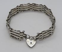 A silver four bar bracelet having hallmarked heart padlock clasp.