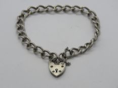 A silver charm bracelet having hallmarked heart padlock clasp.