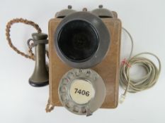 A vintage wall mounted telephone having twin brass hemispherical bells with mouth and ear pieces,