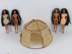 Four Pocahontas dolls made by Mattel, two with dresses, together with hut.