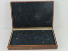 A vintage wooden display box opening to reveal padded fabric lining within, 44 x 29.5 x 7cm.
