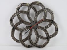 A wall clock formed from eight horseshoes and having central quartz movement, slightly a/f,