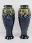 A pair of Royal Doulton Lambeth vases in green and blue with floral urns,