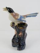 A vase in the form of a bird sitting on glazed 'tree stump' base, 19cm high.