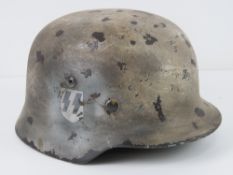 A reproduction WWII German helmet with liner and chin strap.