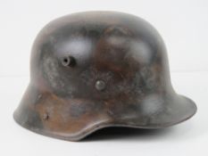 A reproduction WWII German helmet with liner and chin strap.