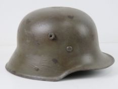 A reproduction WWII German helmet with liner and chin strap.