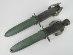 Two M16 bayonets with scabbards and canvas frogs.