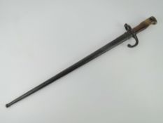 A French Gras bayonet with scabbard and hooked quillion, blade measuring 52cm in length.