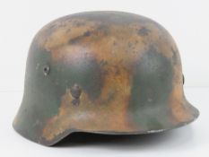A reproduction WWII German helmet with liner and chin strap.