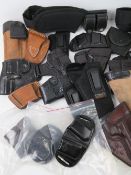 A box containing a quantity of modern holsters, ammo pouches and belts.