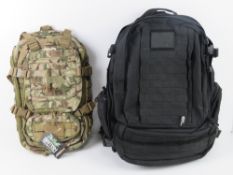Two Kombat day sacks; one being a black tactical assault bag,