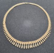 A 9ct gold articulated necklace having three-row panel chain with graduated 'tassles' upon,