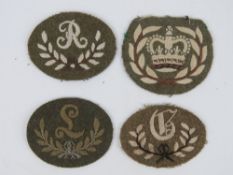 Four assorted WWII British cloth badges, in frames.