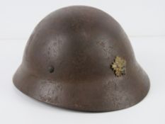 A rare WWII Japanese Police helmet with liner and chin strap. Japanese writing within.